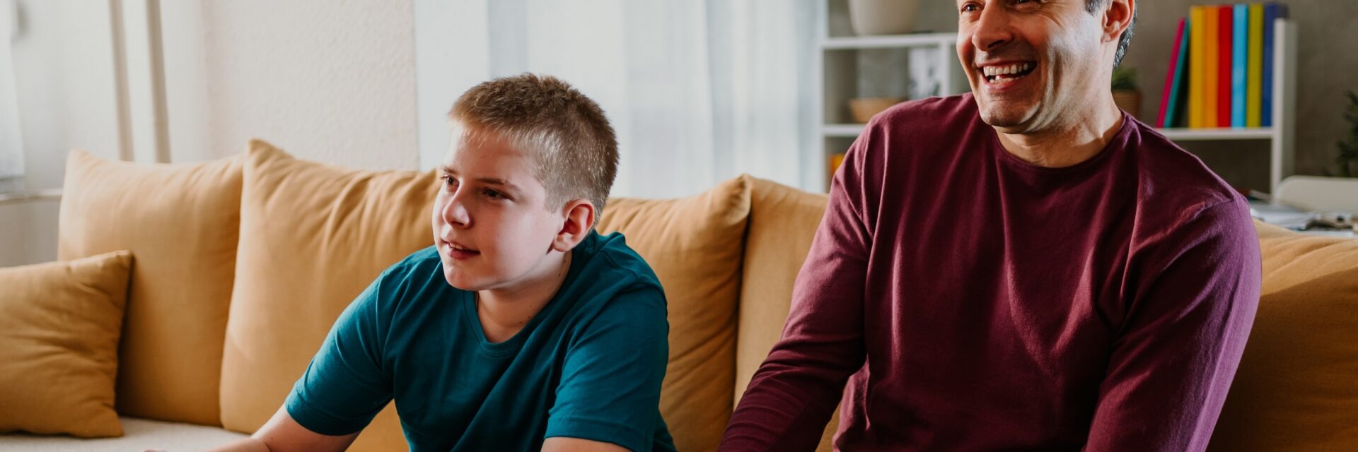 Male support worker and boy playing a games console