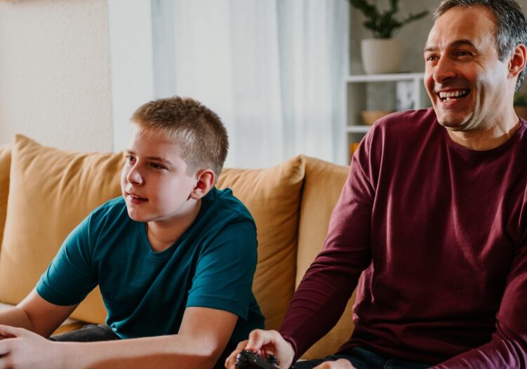 Male support worker and boy playing a games console